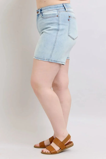 Light wash denim shorts paired with tan flat sandals, side view on model