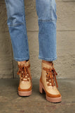 Tan lace-up heeled boots with chunky soles, paired with cropped blue jeans on concrete