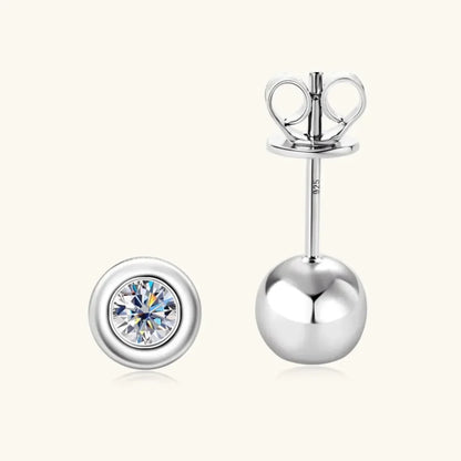 Sterling silver stud earrings with round bezel-set clear gemstone on light background