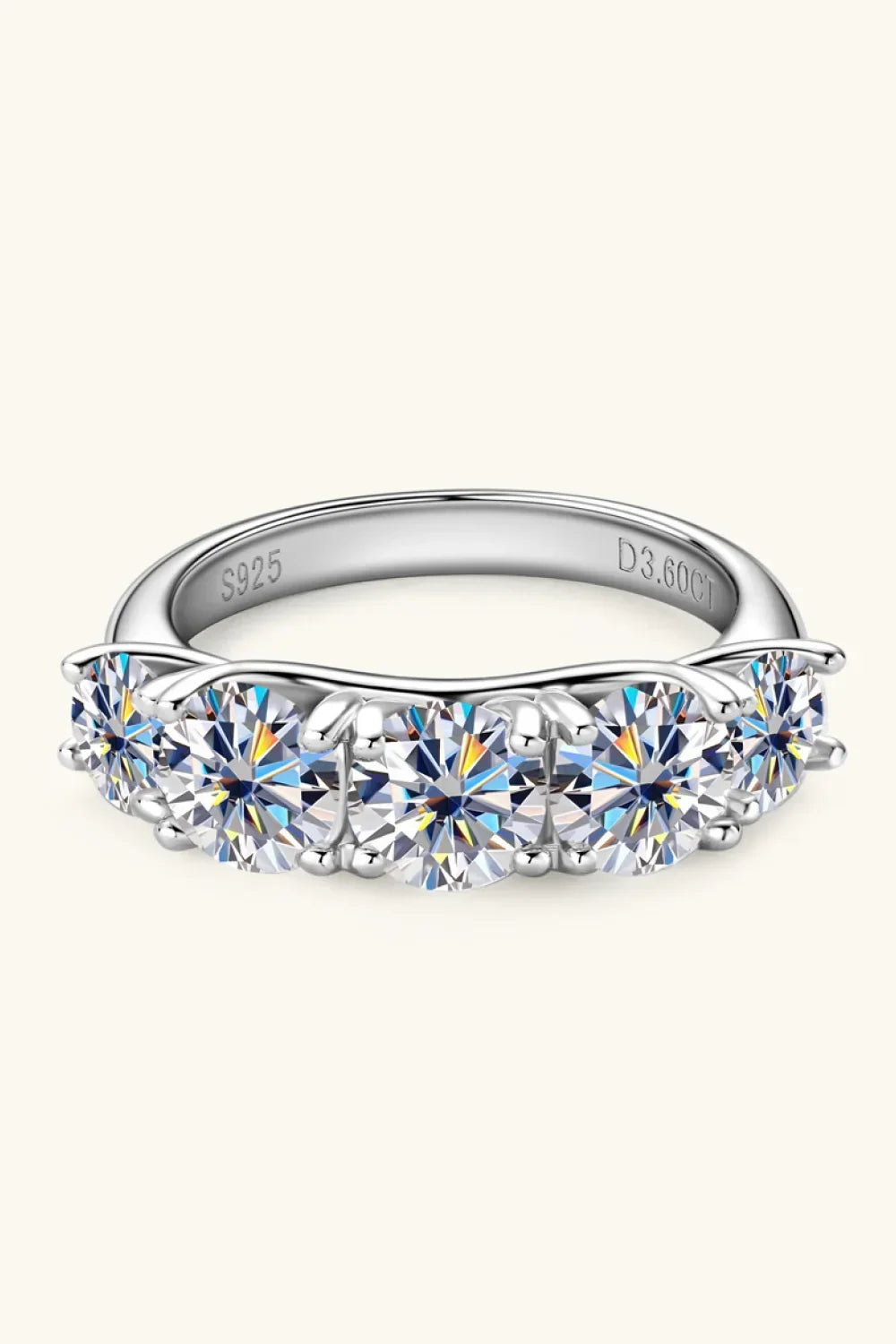 Sterling silver band ring with seven round-cut clear gemstones in prong settings.
