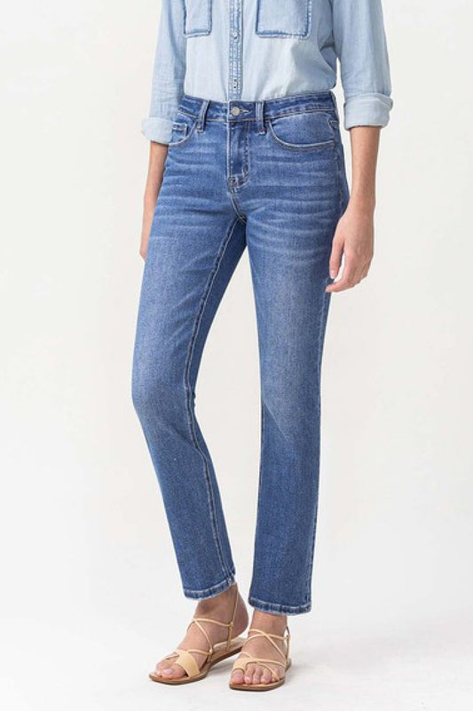 Woman wearing straight-leg blue jeans and light denim shirt with strappy sandals