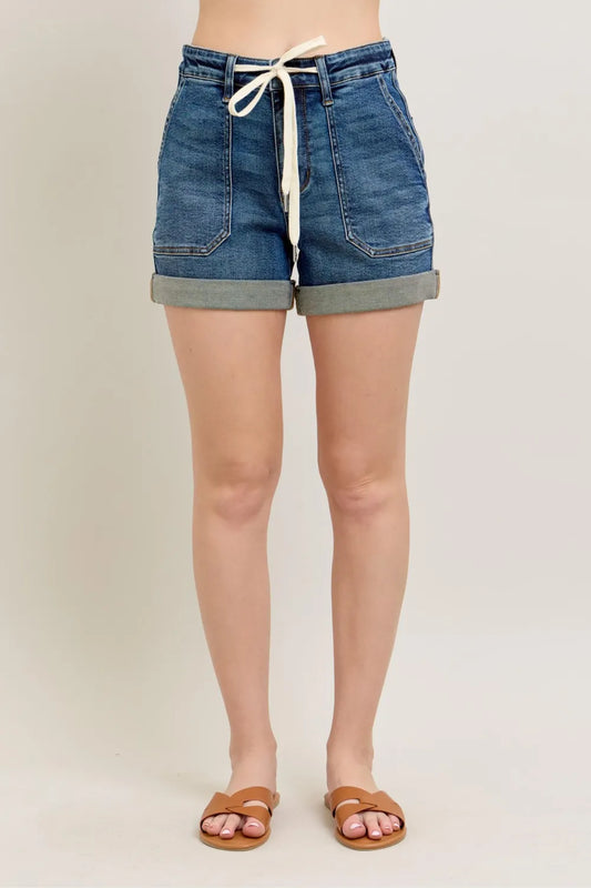 High-waisted denim shorts with rolled hems, front pockets, and white drawstring, modeled.