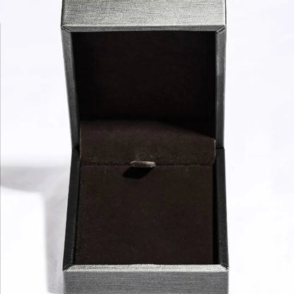 Open black velvet jewelry box with a hinged lid on a white background