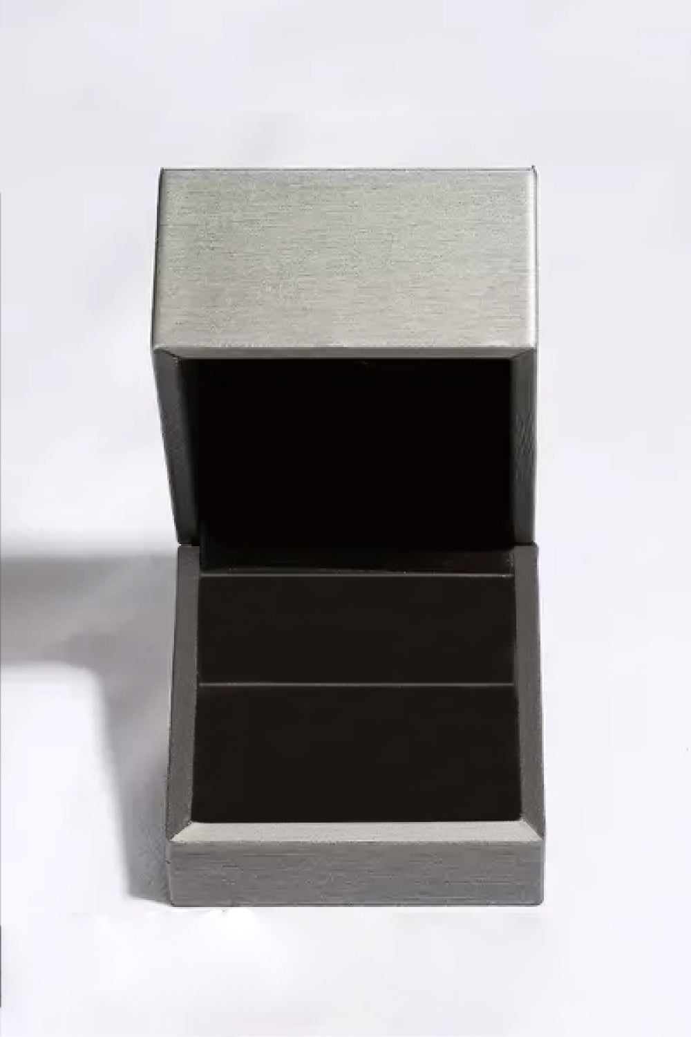 Open empty jewelry box with a sleek metallic finish on a white background