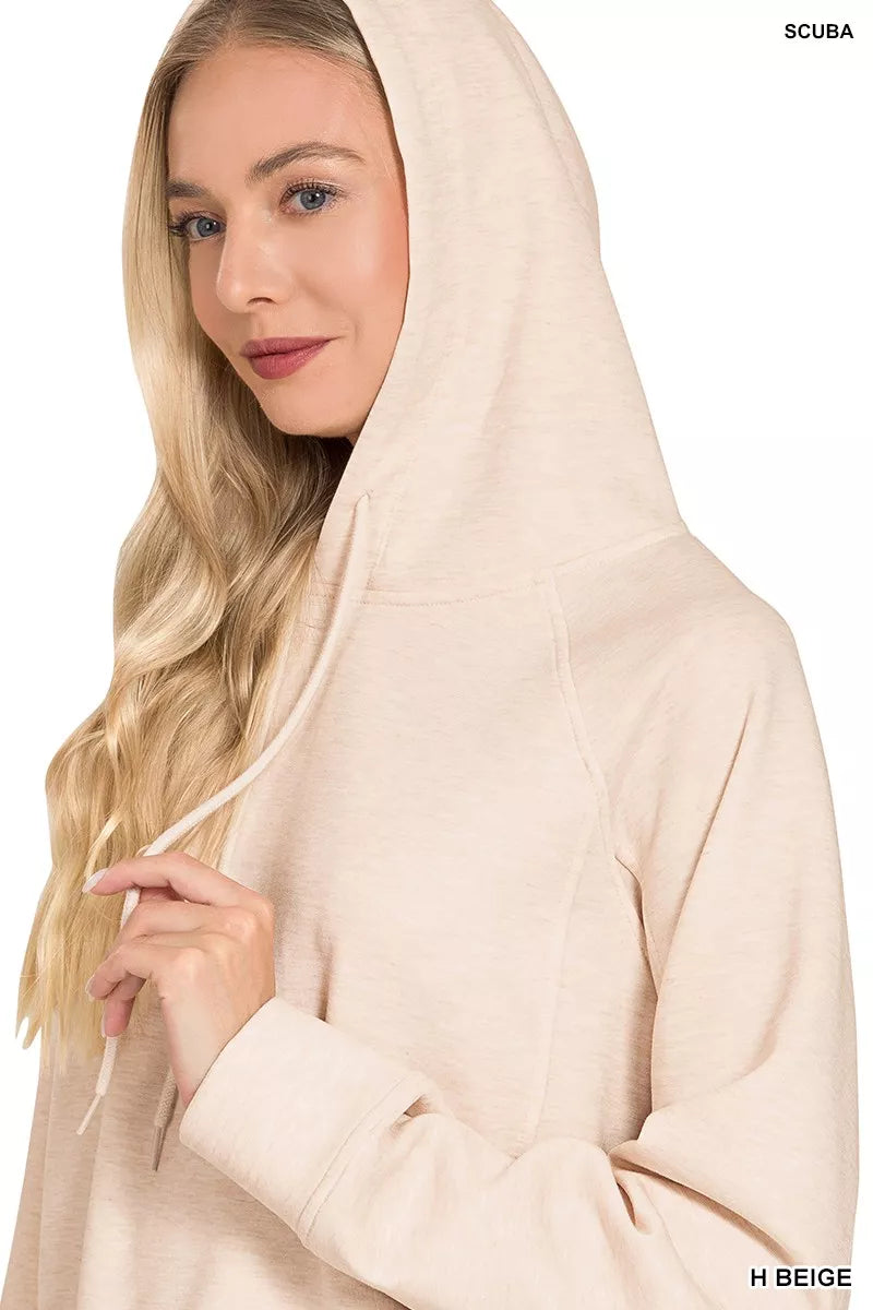 Woman in a beige hoodie with relaxed fit and drawstring detail, neutral background