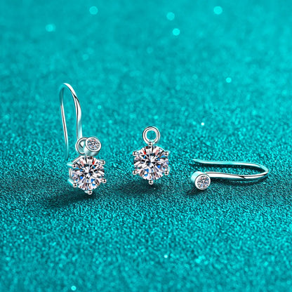 Elegant silver and crystal drop earrings with round stones on a teal textured background