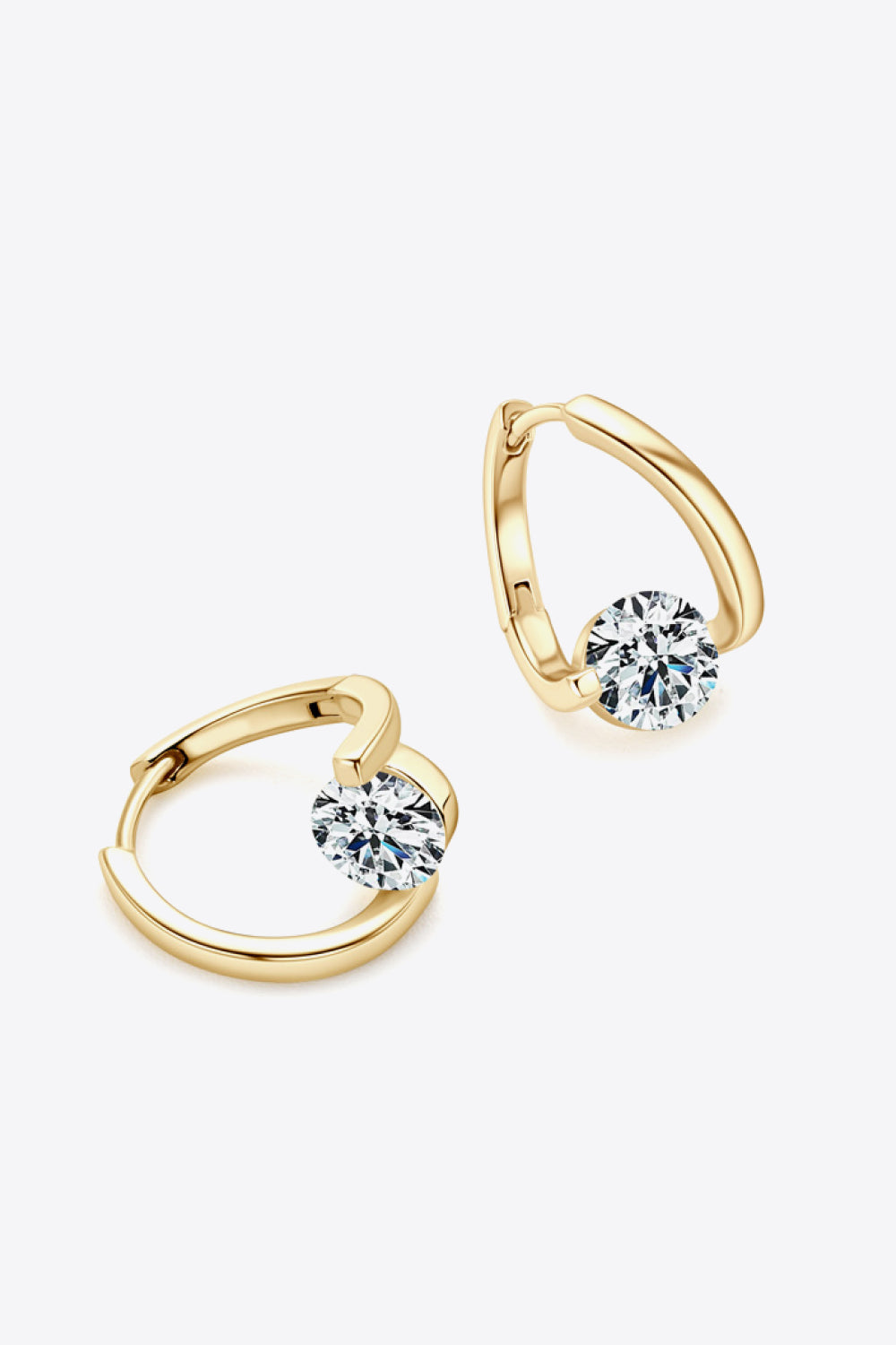 Gold hoop earrings with round clear gemstones on white background