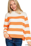Woman wearing a light orange and white striped knit sweater with blue jeans