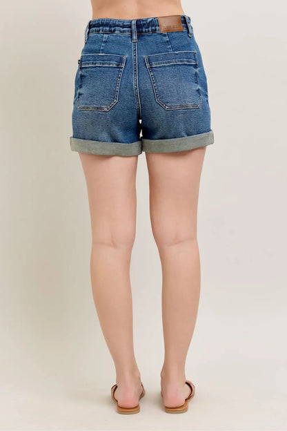 Back view of rolled hem denim shorts with patch pockets, styled with sandals.