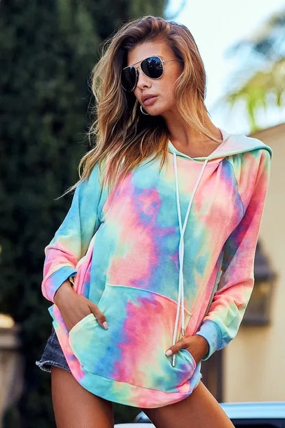 Woman wearing a relaxed tie-dye hoodie with front pocket and drawstrings outdoors