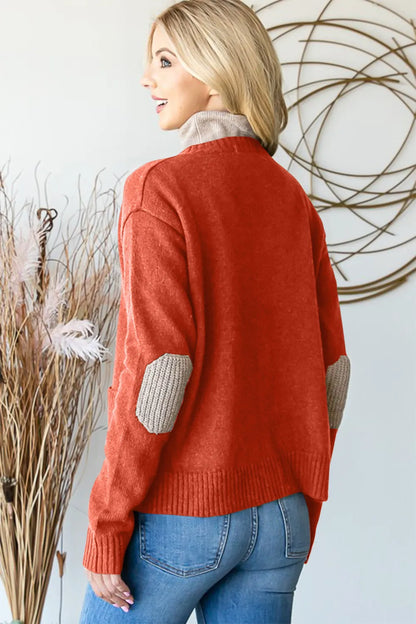 Woman in cozy red sweater with tan elbow patches and blue jeans, modern home decor background