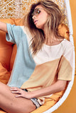 Woman in colorblock ribbed t-shirt and sunglasses lounging in modern white chair