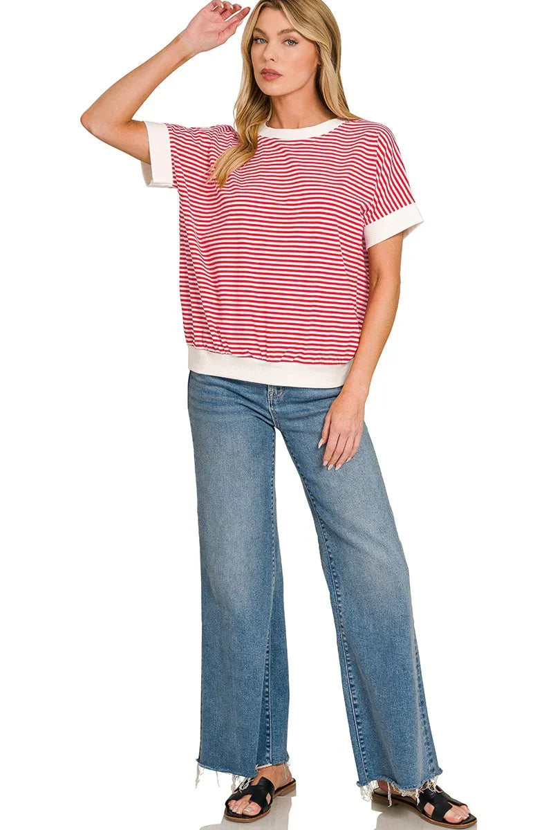 Woman wearing a red and white striped short sleeve top with relaxed fit blue wide-leg jeans