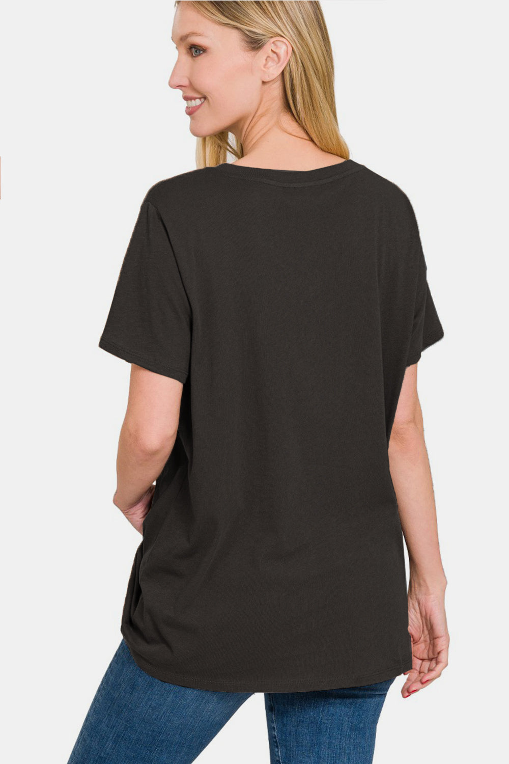 Woman wearing a relaxed fit black t-shirt and blue jeans, back view, against a white background.