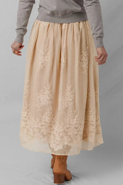 Beige floral embroidered midi skirt paired with a grey sweater and tan heeled boots