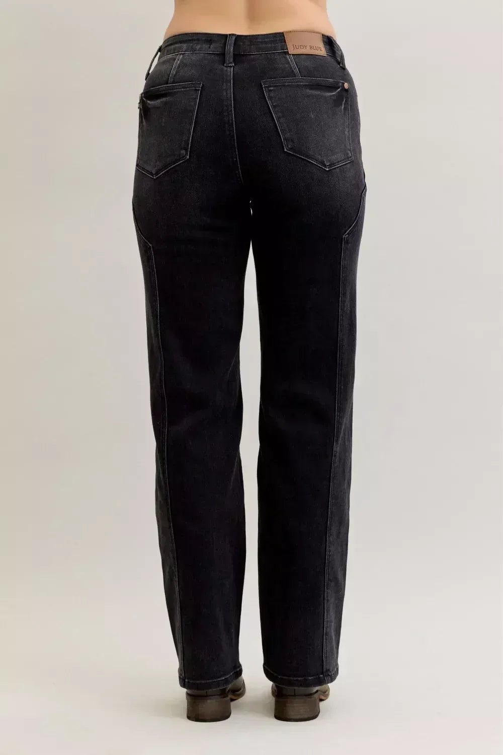 Back view of high-waisted black straight-leg jeans with rear pockets on model