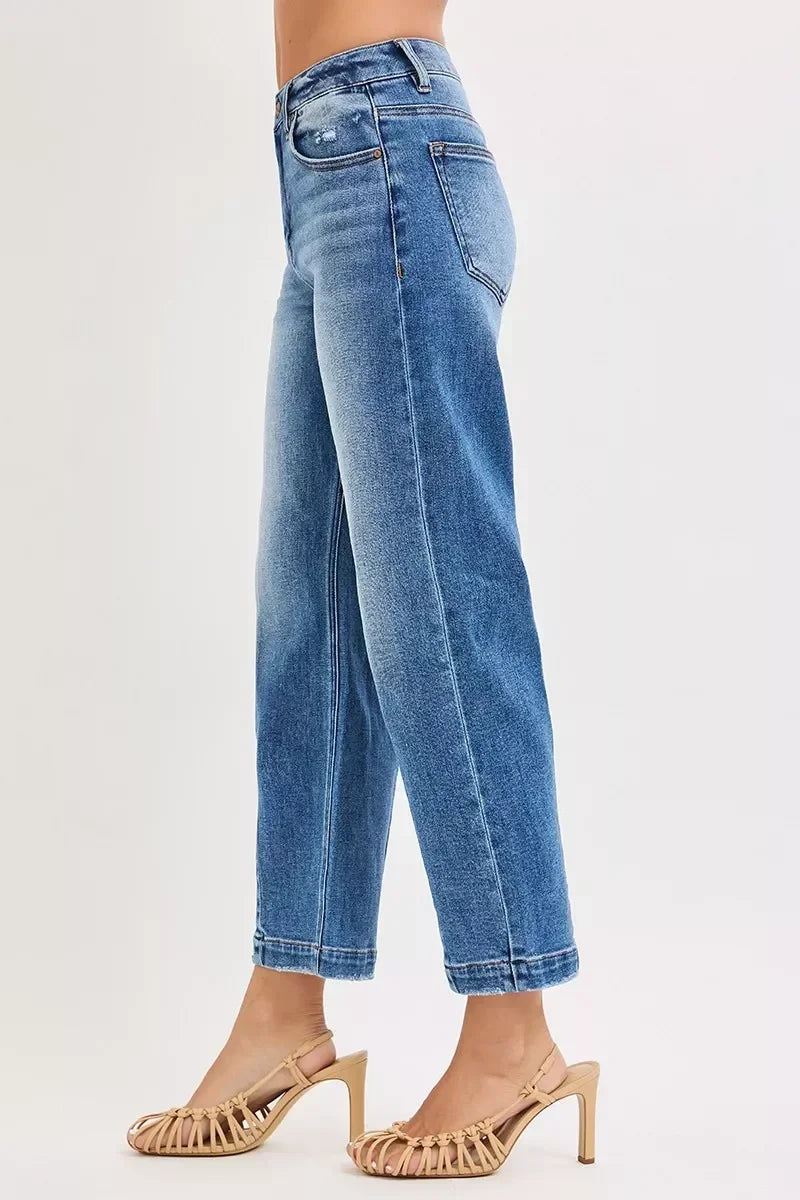 Woman wearing high-waisted straight leg blue jeans and nude heeled sandals