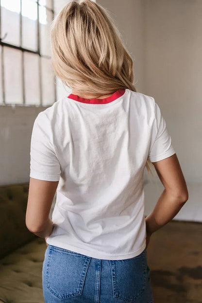 Woman wearing a white short sleeve t-shirt with red collar and blue jeans, back view indoors