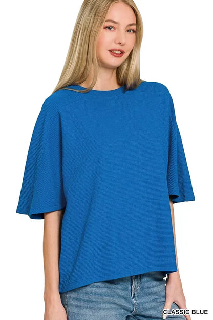 Woman wearing a relaxed fit, textured classic blue short sleeve top with jeans