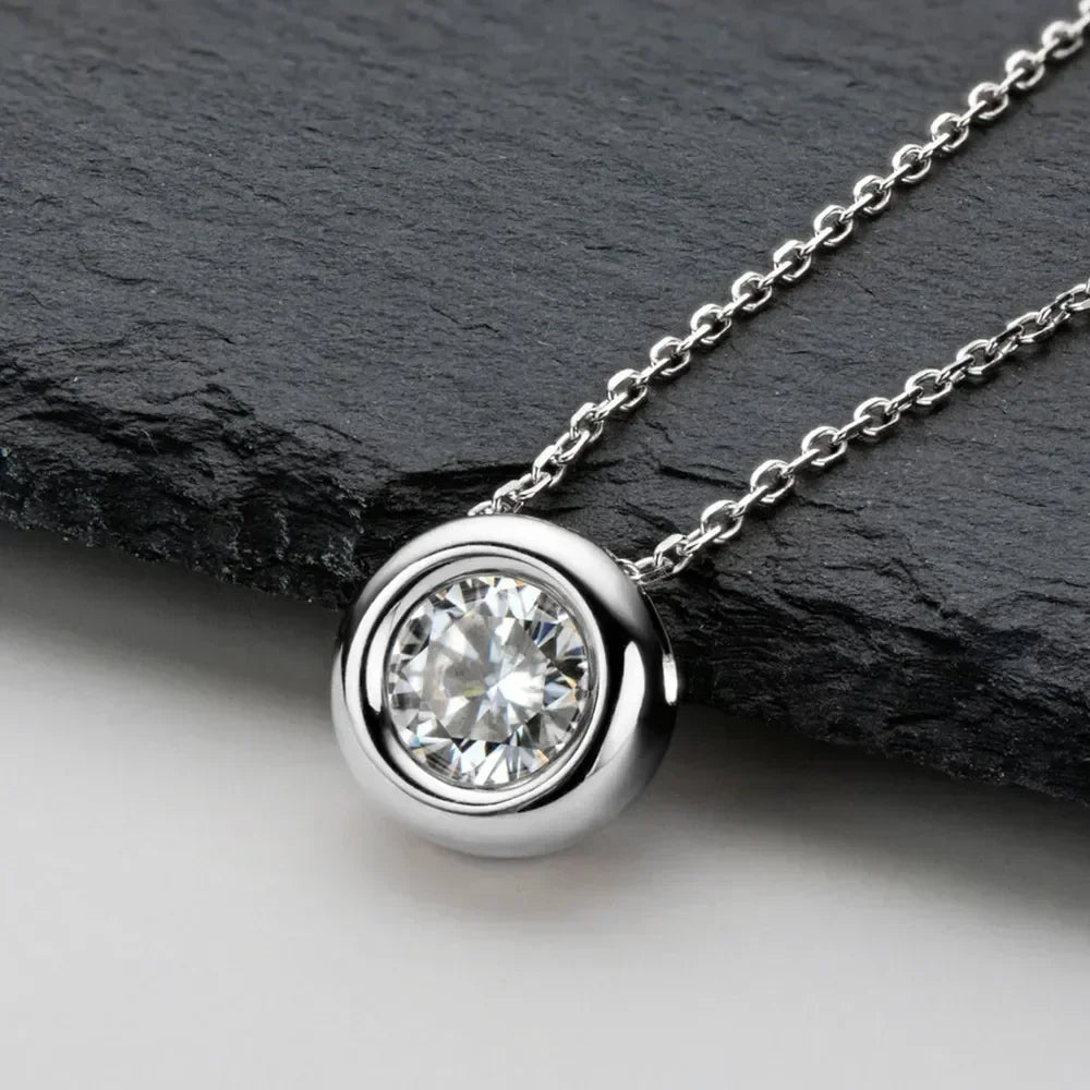 Silver bezel-set solitaire pendant necklace with round clear gemstone on a chain