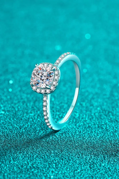 Cushion-cut diamond engagement ring with pavé band on sparkling turquoise background