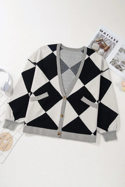 Black and white argyle cardigan with grey trim, button front, and pockets, laid flat on white.