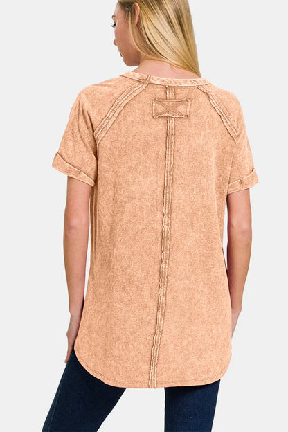 Woman wearing a relaxed fit, short sleeve tan top with raw seam details, back view
