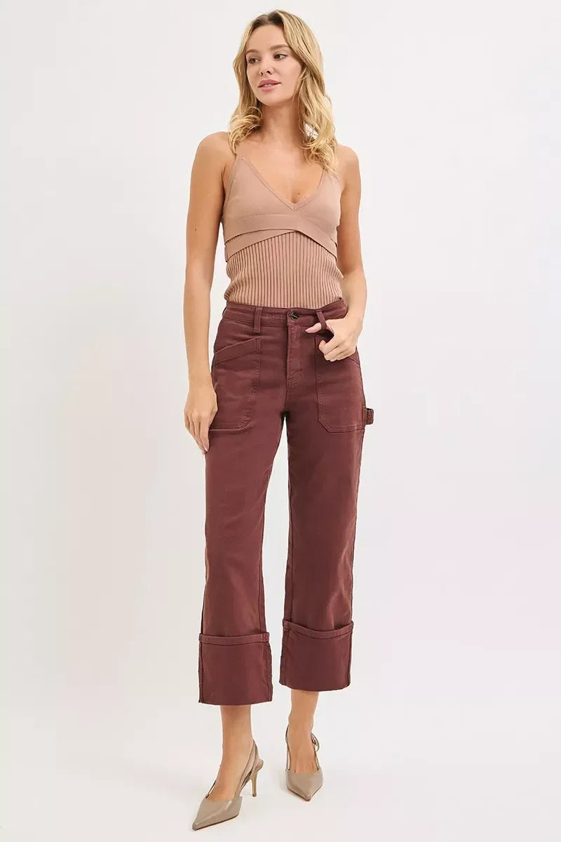Woman wearing a ribbed tan tank top with wide-leg cropped maroon pants and nude heels.