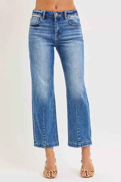 Woman wearing high-waisted, straight-leg blue denim jeans and woven heeled sandals