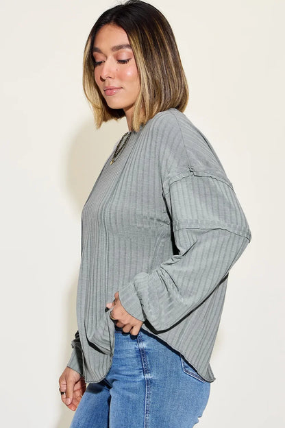 Woman wearing a relaxed fit, ribbed gray long sleeve top with blue jeans
