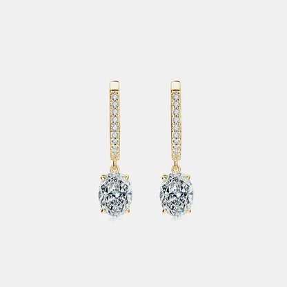 Gold drop earrings with oval clear gemstones and pavé accents on white background