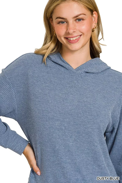 Woman wearing a ribbed dusty blue hoodie with relaxed, casual fit on white background.