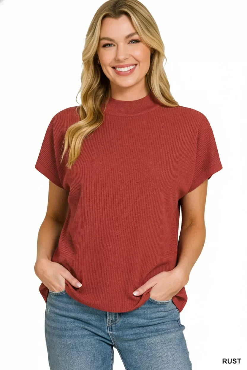 Woman wearing a rust short sleeve ribbed knit top with relaxed fit and blue jeans