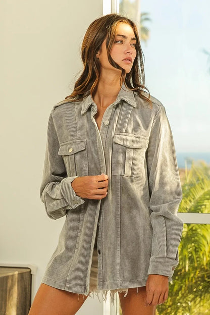 Woman wearing relaxed fit grey corduroy shirt jacket with chest pockets and frayed hem