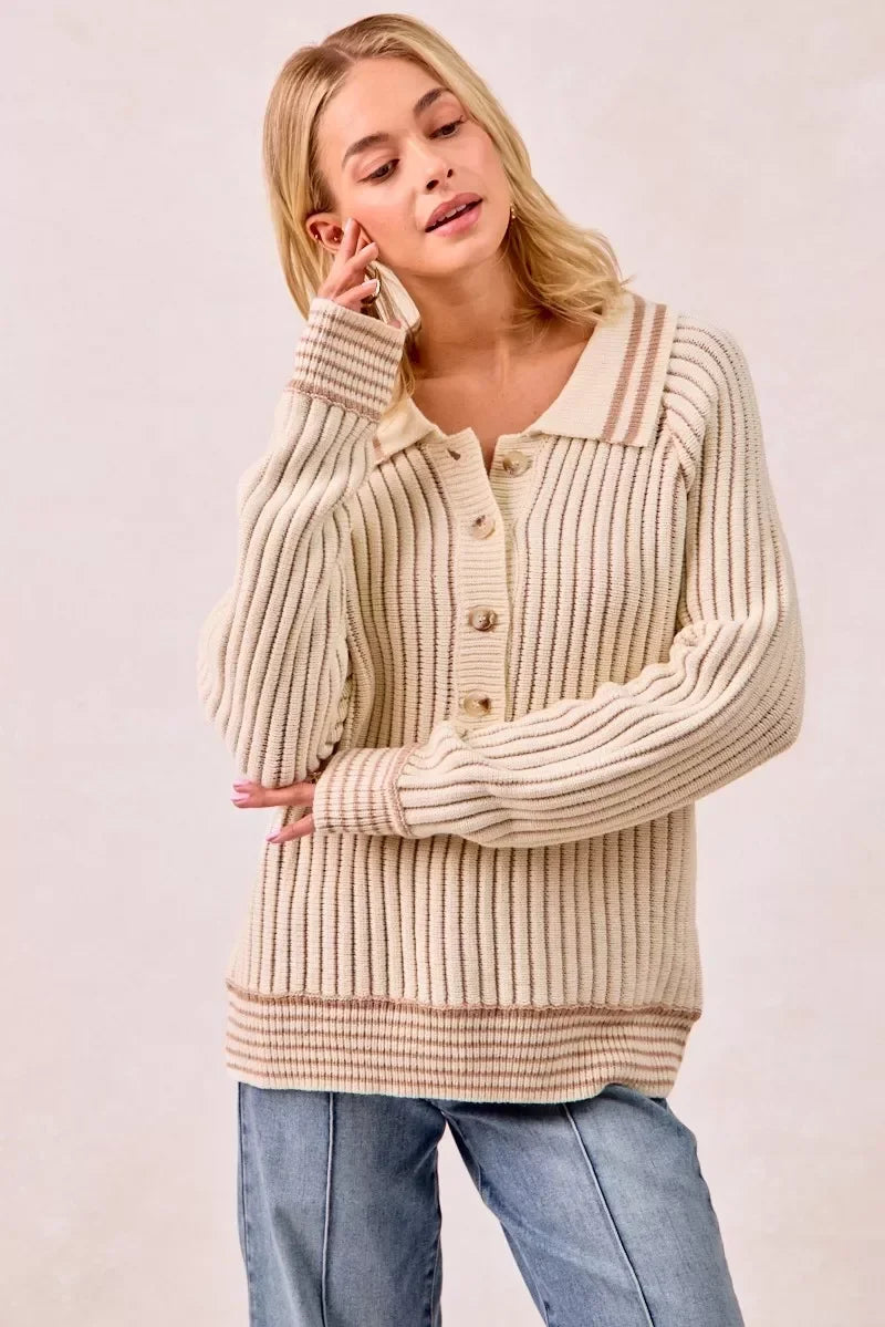 Woman wearing a cream ribbed knit cardigan with button front and relaxed fit, paired with jeans.