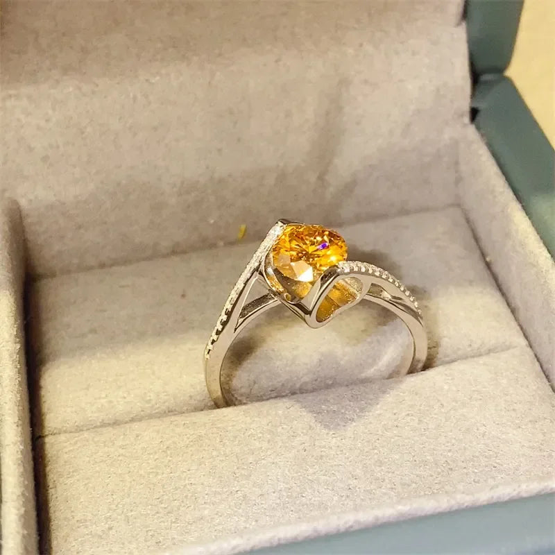 Silver ring with a yellow gemstone and delicate band in a jewelry box