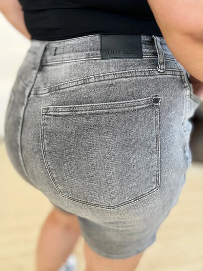 Close-up of woman wearing high-waisted gray denim shorts with back pocket detail