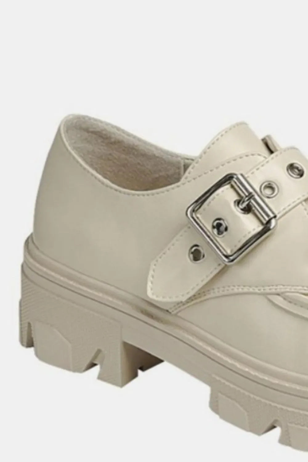 Beige chunky loafer with thick lug sole and silver buckle detail on white background