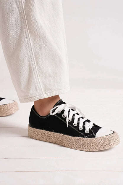 Black canvas platform sneaker with white laces and jute-wrapped sole, styled with light jeans