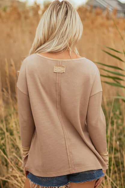 Woman wearing beige waffle knit long sleeve top and denim shorts outdoors