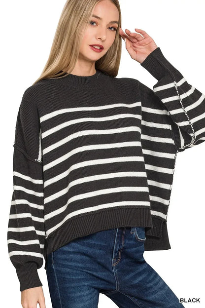 Woman wearing black and white striped knit sweater with relaxed fit and blue jeans