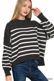 Woman wearing black and white striped knit sweater with relaxed fit and blue jeans