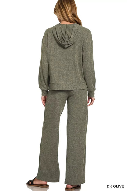 Woman wearing a relaxed fit dark olive ribbed loungewear set with hooded top and wide-leg pants.