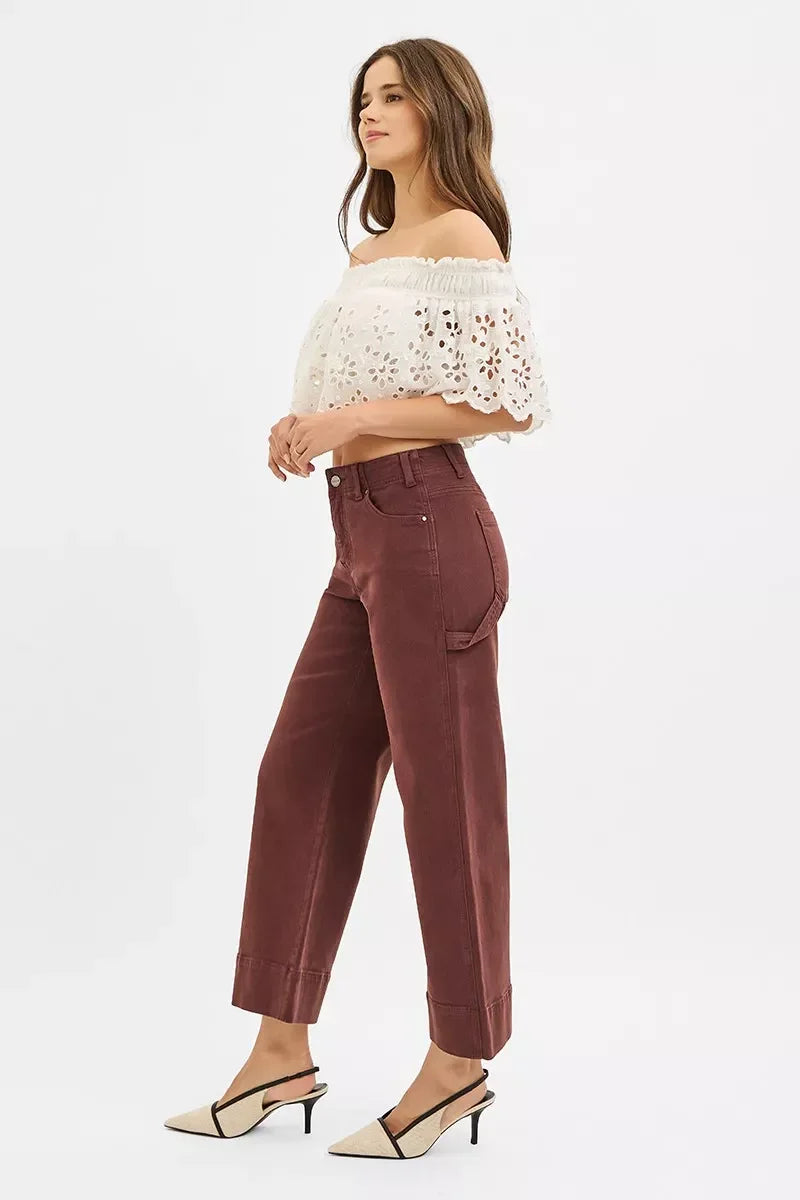 Woman in white eyelet off-shoulder crop top and high-waisted maroon wide-leg pants
