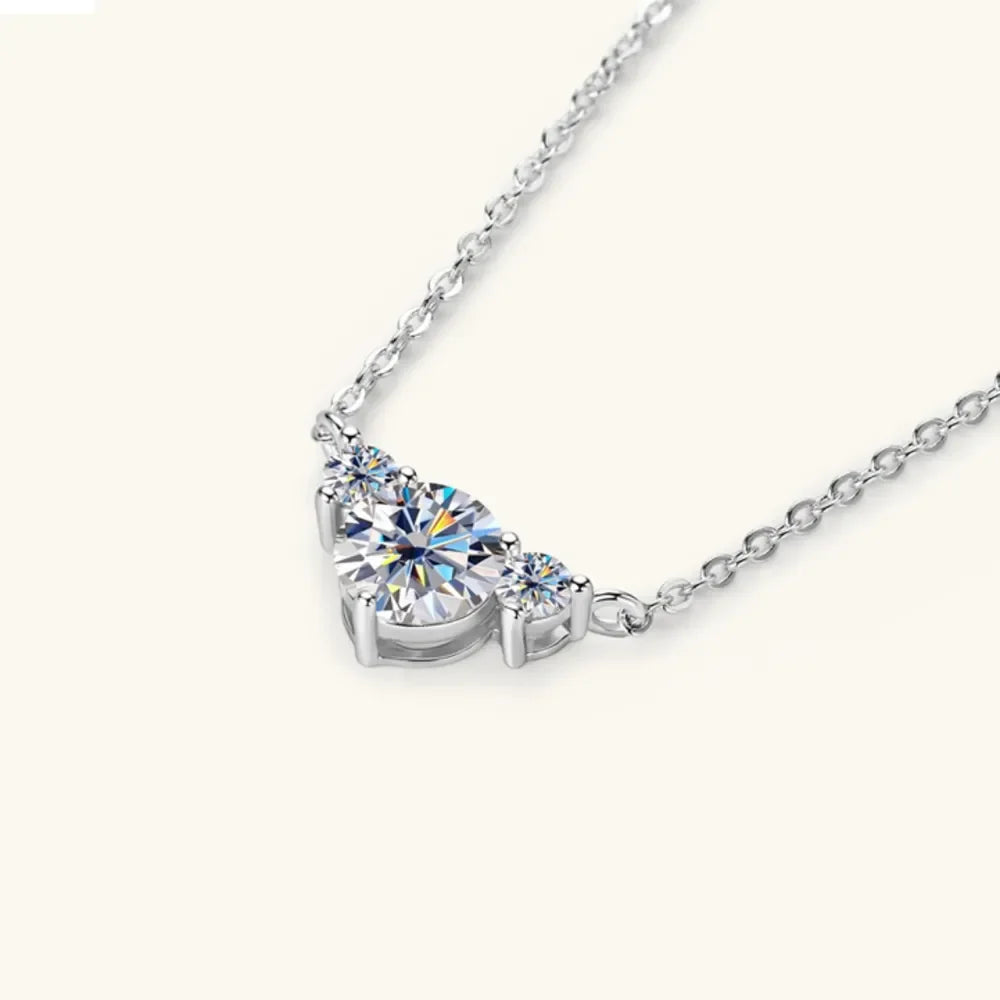 Elegant silver chain necklace with three round clear gemstones on a light background