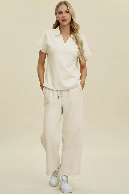 Woman wearing cream textured short sleeve collared top and matching wide-leg pants