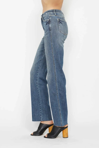 Woman wearing high-waisted straight leg blue jeans and black block heel mules