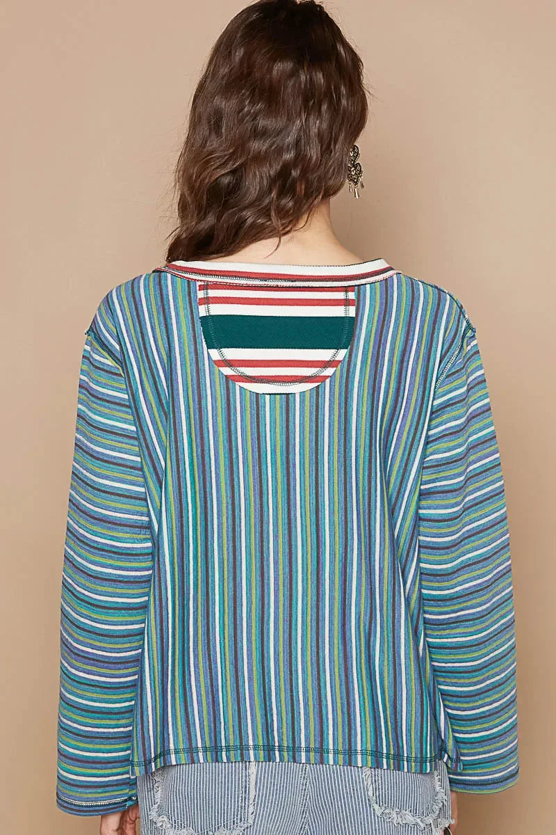 Woman wearing a multicolored vertical striped long sleeve top, shown from the back