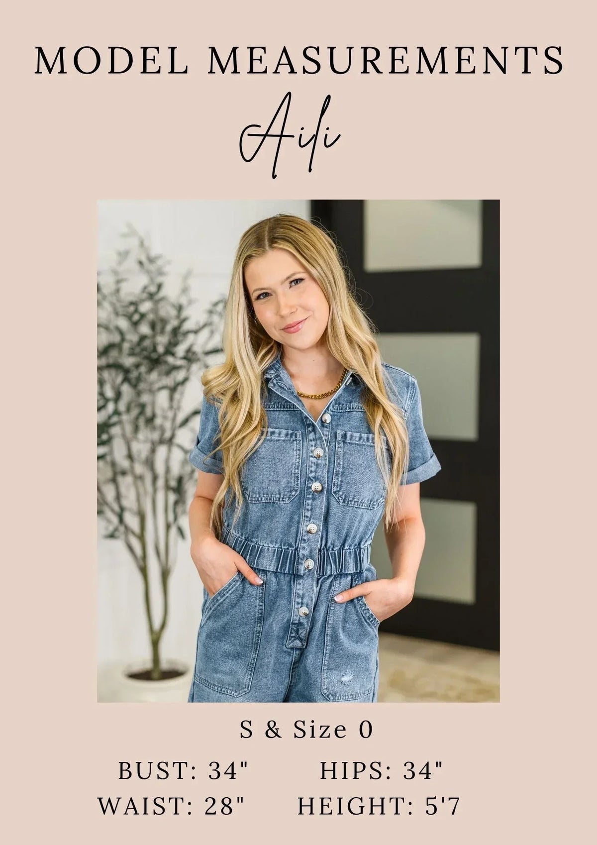 Woman modeling relaxed denim short-sleeve romper with buttons and pockets, indoor setting