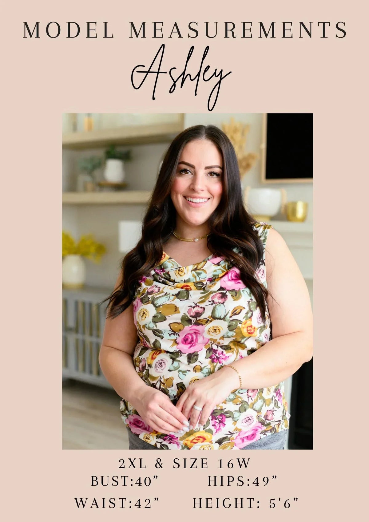 Woman with long dark hair modeling a floral sleeveless top in a bright indoor setting.